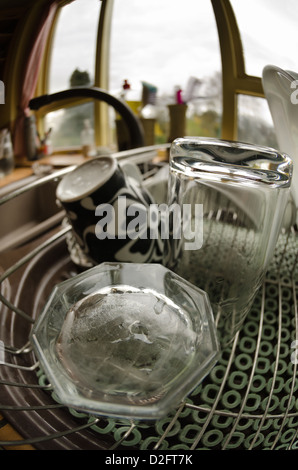 Becher und Gläser auf Abtropffläche in Küche Aufgaben des Tages betonte verzerrt zu reinigen Stockfoto