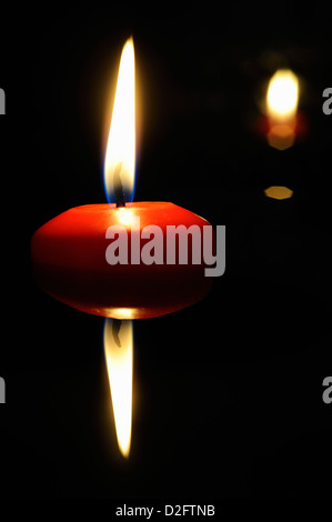 Brennende Kerze in der Nacht vom Wasser reflektiert Stockfoto
