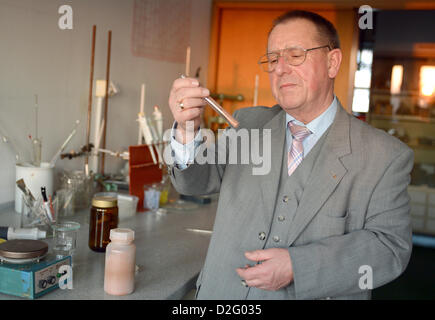 Vorsitzender des Unternehmens, Protektum, Lothar Ebner, blickt auf ein Reagenzglas gefüllt mit der Essenz der roten Trauben, in Oranienburg, Deutschland, 14. November 2012. Protektum produziert Zucker und Alkohol rot Wein Bonbons die Herzinfarkte verhindern sollen. Foto: Britta Pedersen Stockfoto