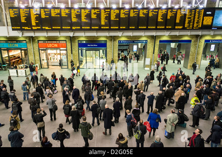 Die Leute am Bahnhof Kings Cross, London, UK - mit Blick auf die Abfahrt Platten im abendlichen Hauptverkehrszeit mit gestrichenen Züge verzögert Stockfoto