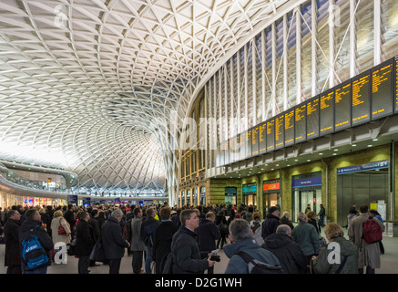 Pendler, Leute, auf der Bahnhofshalle Kings Cross, London, England, Großbritannien in der abendlichen Hauptverkehrszeit mit Zugverspätungen Stockfoto