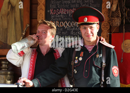 Während ein Festival zwei lokalen Jungs aus Osteuropa sind servieren Wodka und andere alkoholische Getränke hinter einem Getränkestand. Stockfoto
