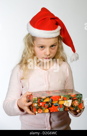 Berlin, Deutschland, das kleine Mädchen mit Weihnachts-Geschenk und Nikolausmuetze Stockfoto