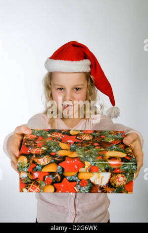 Berlin, Deutschland, das kleine Mädchen mit Weihnachts-Geschenk und Nikolausmuetze Stockfoto