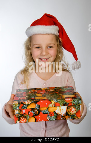 Berlin, Deutschland, das kleine Mädchen mit Weihnachts-Geschenk und Nikolausmuetze Stockfoto