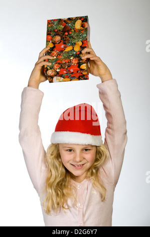 Berlin, Deutschland, das kleine Mädchen mit Weihnachts-Geschenk und Nikolausmuetze Stockfoto