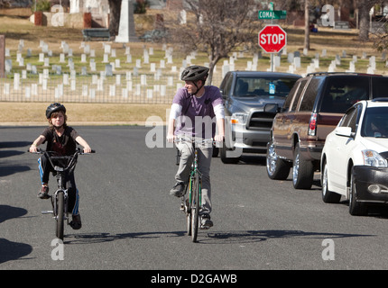 Weißen männlichen Vater und Sohn tragen Schutzhelme Reiten Fahrräder entlang der Straße in Austin, Texas Stockfoto