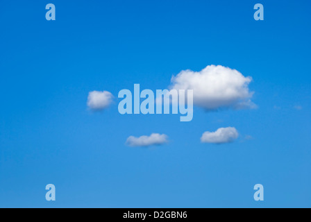 Vier weiße flauschige oder Watte wie Wolken schweben gegen eine perfekte klaren blauen Himmel Stockfoto