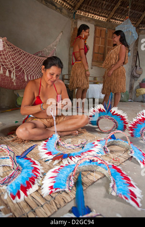 Brasilianische Pataxo indigene Frauen machen traditionelle Kopfkleider aus Papageienfedern, Bahia, Brasilien, Südamerika Stockfoto