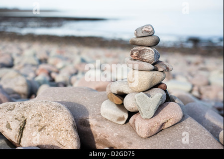 Herzförmigen Stein mit einem Stapel von Steinen am Strand von Porlock Weir, Somerset, England, Vereinigtes Königreich Stockfoto