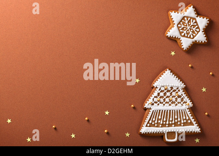 Weihnachten-Lebkuchen-Komposition mit goldenen Sternen und Kugeln auf braunem Papierhintergrund Stockfoto