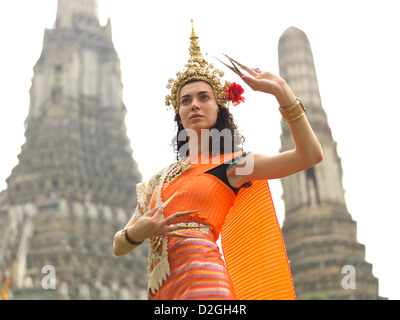 Frau in traditioneller thai Kostüm posiert vor Wat Arun Tempel der Morgenröte in Bangkok, Thailand Stockfoto