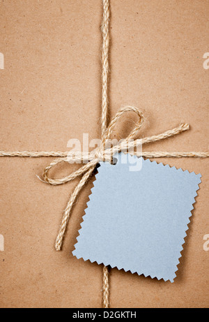Geschenk-Paket und blauen Tag in braunem Papier Wrapper mit Schnur gebunden hautnah Stockfoto