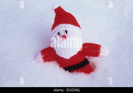 Gestrickte Weihnachtsmann Stofftier bis zur Taille im weichen Schnee versenkt Stockfoto