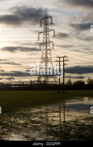 Großen Strommasten spiegelt sich in einem feuchten Bereich in Großbritannien. Stockfoto