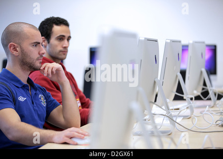 Zwei männliche Studenten mit iMac Apple-Computern. Computer / es Zimmer in University, UK.