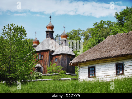 Traditionelle slawische Dorf mit hölzerne orthodoxe Kirche und Haus mit Strohdach Stockfoto