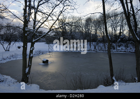 Zugefrorenen Teich an einem schneereichen Winter-Nachmittag Bromley Kent England Stockfoto