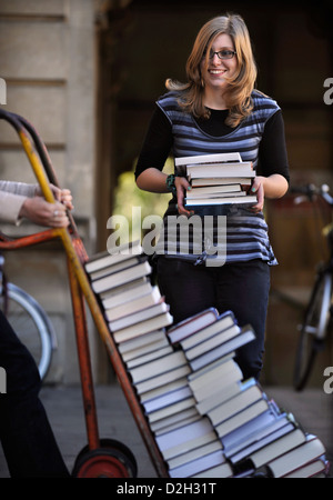 Festivalorganisatoren manövrieren einen Stapel Bücher auf einem Sack-LKW auf dem Cheltenham Literaturfestival UK Stockfoto