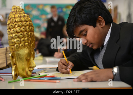 Ein elfjähriger Junge, zeichnen eine Maske in einem Kunstunterricht an Pasteten Grammar School in Cheltenham, Gloucestershire UK Stockfoto