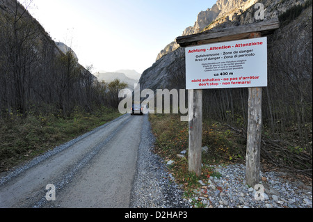 Eine Schotterstraße in den Schweizer Alpen, die Steinschläge haftet. Hinweises Treiber nicht zu stoppen. Stockfoto