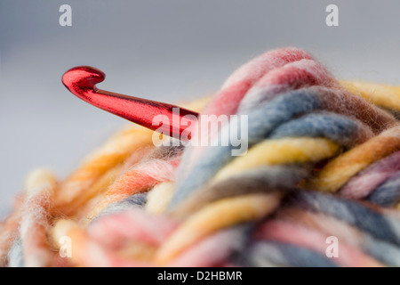 Nahaufnahme von einem roten in ein mehrfarbiges Garn. Stockfoto