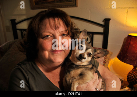 Chronisch Kranken senior hält ihr Haustieren Hund. Stockfoto