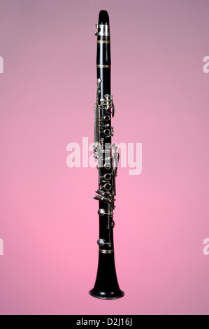 Eine Klarinette ist in der Nähe, auf einem rosa Hintergrund fotografiert. Das Holzblasinstrument ist ein Grundnahrungsmittel in marching Band oder Orchester. Stockfoto