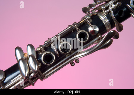 Eine Klarinette ist in der Nähe, auf einem rosa Hintergrund fotografiert. Das Holzblasinstrument ist ein Grundnahrungsmittel in marching Band oder Orchester. Stockfoto