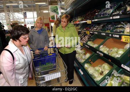 Zwei junge Frauen mit einer geistigen Behinderung einkaufen gehen mit ihrer Unterstützung Arbeiter, Skipton, North Yorkshire. Stockfoto