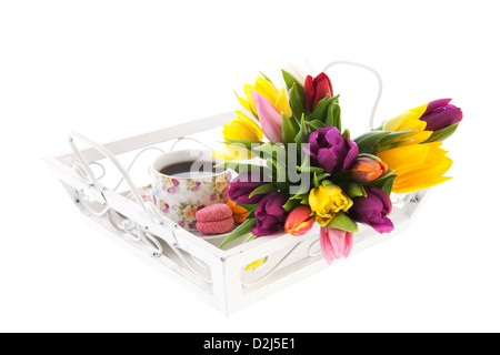 Tasse Tee in fröhlichen Tasse mit Makronen und Blumen auf weiß Tablett Stockfoto