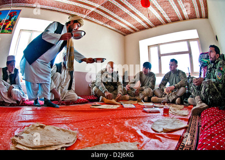 Ein afghanischer Dorfbewohner bietet Nahrung für US-Armee Soldaten während eines Treffens mit Dorfältesten 5. Mai 2012 in Provinz Ghazni, Afghanistan. Das Fladenbrot im Bild wurde aus Weizenmehl, die von der afghanischen ältere Familie gewachsen. Stockfoto