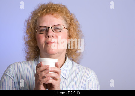 Studioaufnahme mittlere gealterte Frau mit lockigen roten Haaren Stockfoto