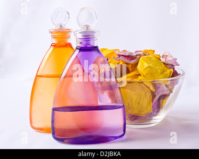 Lavendel und Arnika Öl, rosa Blüten in einer Glasvase Stockfoto