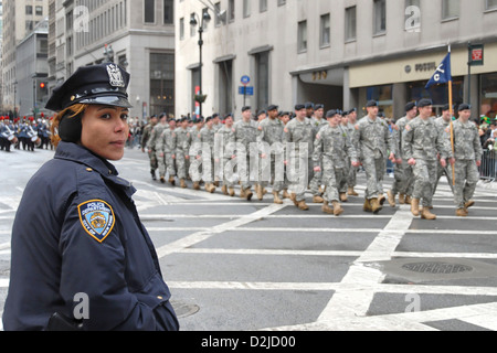 New York City, USA, ein Polizist am Rande der Parade und marschierenden UNSCDF Stockfoto