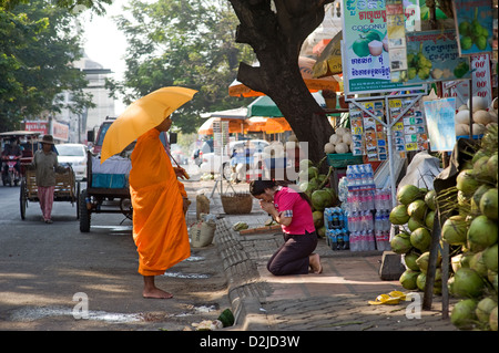 Phnom Penh, Kambodscha, betet eine Frau vor einem buddhistischen Mönch Stockfoto