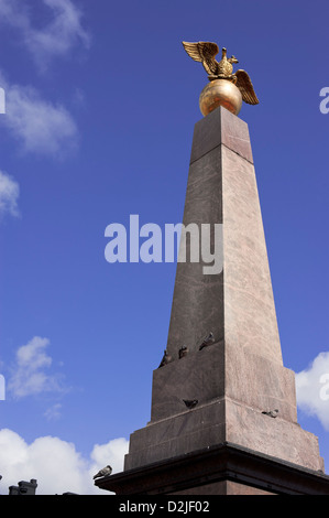 Obelisk mit einem goldenen Adler in der Gegend und Tauben Stockfoto