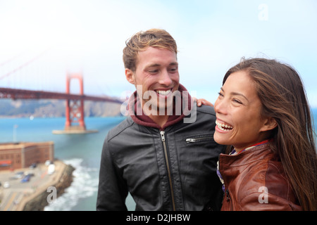 Glückliches junges Paar lachend in San Francisco durch die Golden Gate Bridge. Interracial junge moderne Paare, Asiatin, kaukasischen Mann Stockfoto
