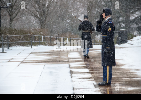 Soldaten nehmen Teil an den Wechsel der Wachablösung am Grab des unbekannten auf dem Nationalfriedhof Arlington in den Schnee. Am nächsten an der Kamera ist das Relief Kommandant. Hinter ihm ist die Wache wird am Ende seiner Schicht entlastet. Stockfoto