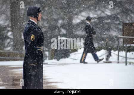 Grabmal der Unbekannten Soldier Guard in Snow Arlington Virginia // ARLINGTON, Virginia — Ein Soldat steht während des Schneefalls am Grabmal der Unbekannten auf dem Arlington National Cemetery. Der Wächter des 3. US-Infanterieregiments behält die zeremonielle Wache trotz Winterwetter. Die Wache folgt einer präzisen 21-stufigen Routine, marschiert entlang der schwarzen Matte hinter dem Grab, bevor sie sich für 21 Sekunden nach Osten und dann für 21 Sekunden nach Norden wendet. Das Grab des unbekannten Soldaten wird seit 1937 24 Stunden am Tag, 365 Tage im Jahr bewacht. Stockfoto