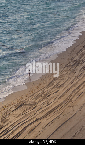 Ein Walker bei Sonnenuntergang am Sunny Isles Beach nördlich von Miami, Florida Stockfoto