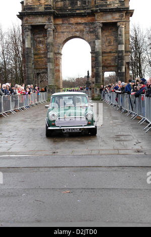 Glasgow Green, Glasgow, Schottland, Großbritannien, Samstag, 26. Januar 2013. Zuschauer beobachten einen Mini Cooper, der nach dem Start der Monte Carlo Classic Rallye mit dem McLennan Arch im Hintergrund abfährt Stockfoto