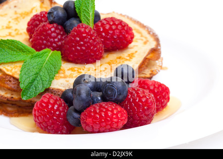 Leckere frisch zubereitet Pfannkuchen mit Honig und Beeren auf weißem Hintergrund Stockfoto