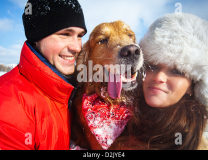 Junges Paar mit Hund zwinkert Porträt. Stockfoto