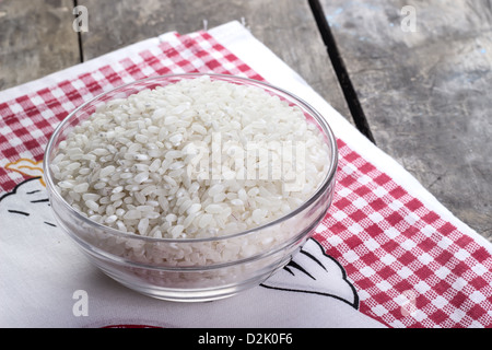 Reis in eine Glasschüssel auf alten Holztisch Stockfoto