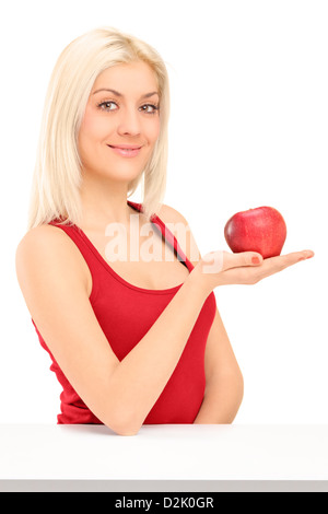 Junge, blonde Frau hält einen roten Apfel isoliert auf weißem Hintergrund Stockfoto