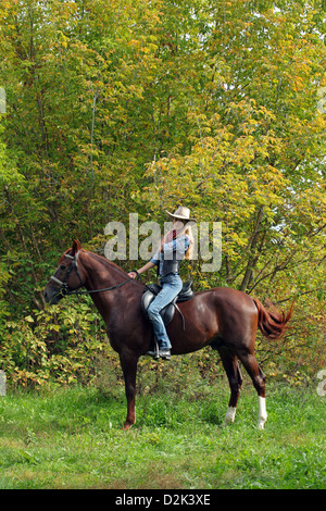 Junge Cowgirl auf Reiten eine Spur in den Nachmittag Tageslicht Stockfoto