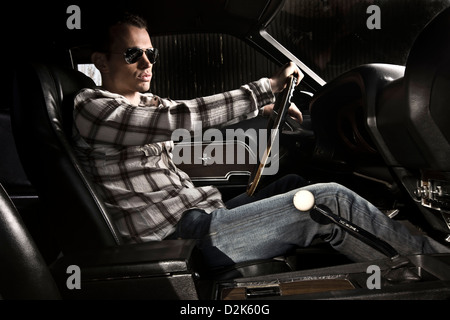 Junger Mann am Lenkrad des Ford Mustang Boss 429 Sportwagen Stockfoto