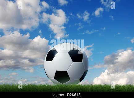 Fußball auf dem Rasen mit Himmel und Wolken im Hintergrund. Erdgeschoss-Seitenansicht. Stockfoto