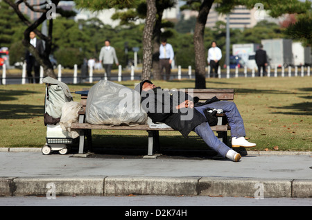 Tokio, Japan, Symbol Foto Armut, schläft ein Mann auf einer Parkbank Stockfoto